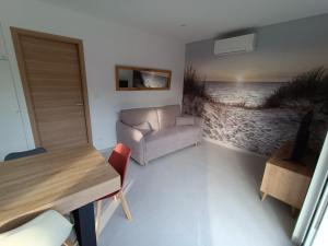 a living room with a couch and a table at Maison T2 avec jacuzzi in Ensuès-la-Redonne
