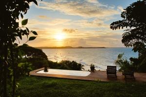 a sunset over the water with a hot tub at Pipa Villa ByBeck - Praia do Amor - Casa inteira in Pipa