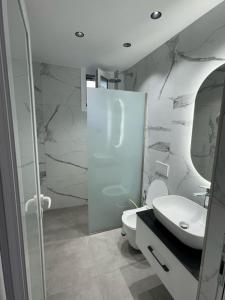 a bathroom with a sink and a toilet and a shower at Adem Hillcrest Apartments in Sarandë +95 photos