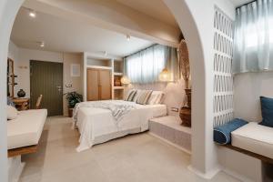 a bedroom with a white bed and a couch at Chic Elysium - Refuge in Naxos Chora