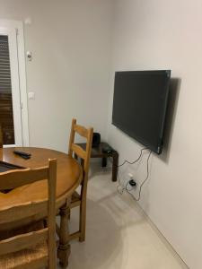 a room with a table and a television on a wall at Appartement 4 pièces dans une maison au calme in Bonneville