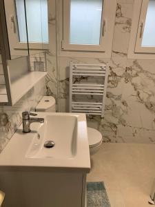 a bathroom with a sink and a toilet at Appartement 4 pièces dans une maison au calme in Bonneville