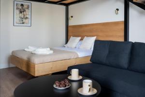 una habitación con una cama y un sofá y una mesa en Indigo Apartments Loft, en Białystok