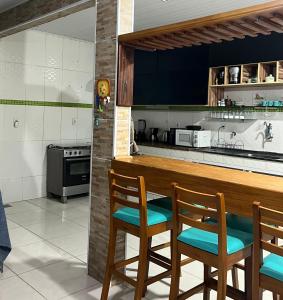 布希奥斯Arara Pousada Búzios的厨房配有带椅子和炉灶的柜台