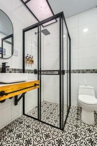 a bathroom with a shower and a toilet at Cocli Hotel Roldanillo in Roldanillo