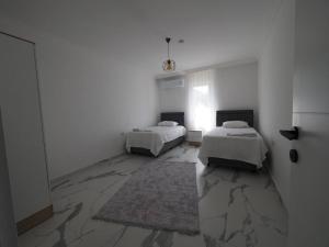 a white room with two beds and a window at MEY Apart in Kaş