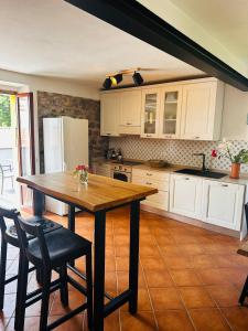 a kitchen with a wooden table and white cabinets at Sole di Bagnone in Bagnone +27 photos