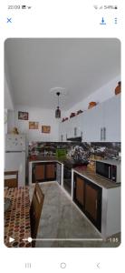 a large kitchen with white cabinets and appliances at Résidence Aslouni Aach el vaz saket Béjaïa Algérie in Bejaïa