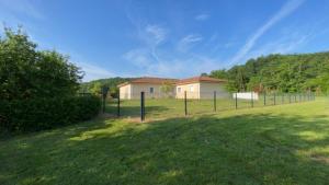 a fence in front of a house in a field at Maison vacances - cure thermale in Eugénie-les-Bains