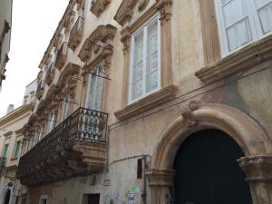 a building with an arch and a balcony on it at Palazzo Doxi Fontana Dimora Storica in Gallipoli