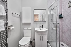a bathroom with a toilet and a sink and a shower at Dunluce Green 1 - Portrush by the Sea in Portrush +33 photos