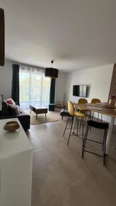 a living room with a couch and a table and chairs at Chez Moumoune in Saint-Valéry-en-Caux