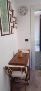 サンニコーラにあるCasa Giovanninaの壁掛け時計付きの部屋のテーブル