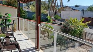 a balcony with chairs and plants on a patio at Hostel caminho da Serra in São Pedro