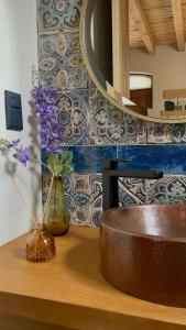 a bathroom counter with a vase of flowers and a mirror at Casa Cairo Pátzcuaro in Pátzcuaro