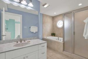 a bathroom with a sink and a shower and a tub at Oceanview on Tybee 202-3 in Tybee Island +36 photos