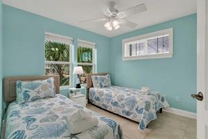 a bedroom with blue walls and a bed and a fan at Oceanview on Tybee 202-1 in Tybee Island