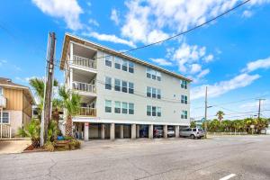a white building with a car parked in front of it at Oceanview on Tybee 202-1 in Tybee Island