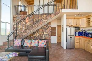 a living room with a couch and a staircase at En'kanto Valle de Guadalupe in San Marcos