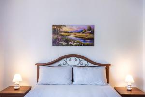 a bedroom with a bed with white sheets and two lamps at La Dimora dei Dolci Ricordi Trasimeno Hideaway in Casalini +49 photos