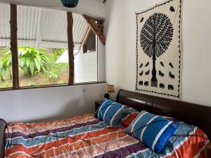 a bedroom with a bed with a tree picture on the wall at Entire home plus pool between Cahuita and Puerto Viejo Excellent Location in Puerto Viejo +59 photos