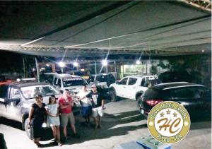 een groep mensen die voor geparkeerde auto's staan bij Pisco Hospedaje Corina in Pisco