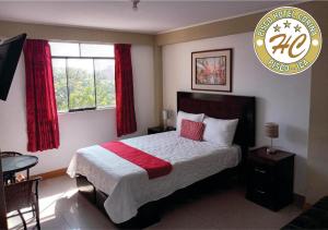 een slaapkamer met een groot bed met rode gordijnen bij Pisco Hospedaje Corina in Pisco