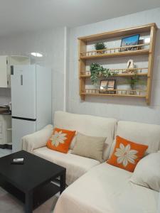 a living room with two white couches and a table at Apartamento Brañas in Cambados