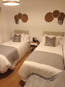 a bedroom with two beds and two mirrors on the wall at Apartamento Brañas in Cambados