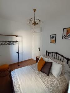 a bedroom with a bed and a chandelier at Apartamento Brañas Home1 in Cambados