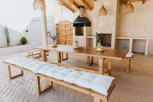un gran patio con mesa de madera y bancos en La Toscana Casa Rural piscina ,parking ,barbacoa, en Jadraque