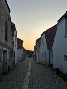 una persona caminando por una calle adoquinada con edificios en Sklípek u Hikešů, en Hnanice 9 fotos más