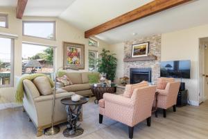 a living room with a couch and chairs and a fireplace at Beachcomber Monthly Only in Cambria