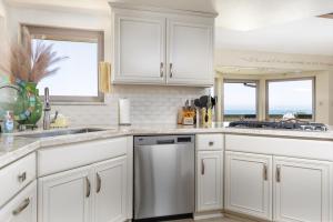 a kitchen with white cabinets and a dishwasher at Beachcomber Monthly Only in Cambria +13 photos