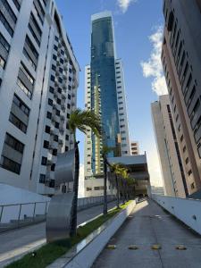 a city street with palm trees and tall buildings at BCE Flat Beira Mar Boa Viagem in Recife