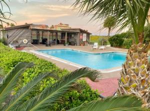 an image of a swimming pool in front of a house at Panoramic Ocean View Condo in Galveston