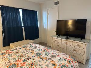 a bedroom with a bed and a flat screen tv at Panoramic Ocean View Condo in Galveston