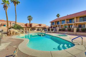 een zwembad tegenover een hotel met palmbomen bij Walk to Rotary Park LHC Condo with Private Patio in Lake Havasu City