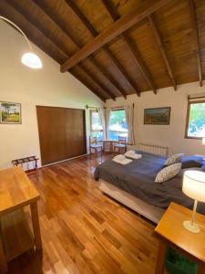 Un dormitorio con una cama grande y suelo de madera. en Pircas del Alto, en Villa La Angostura