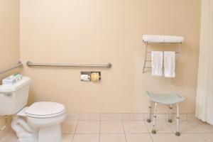 bagno con servizi igienici e sedia blu di Starlight Inn & Suites Motel 29 Palms Joshua Tree National Park a Twentynine Palms