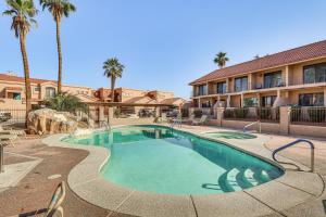 Una piscina frente a un hotel con palmeras. en 1 Mi to Beach Condo with Pool in Lake Havasu City, en Lake Havasu City