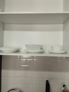 uma prateleira com pratos e tigelas na cozinha em Open Suite 3 em Temuco