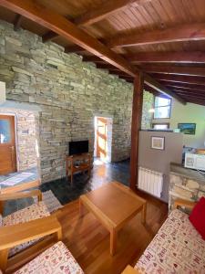 una gran sala de estar con una pared de piedra. en Pircas del Alto, en Villa La Angostura