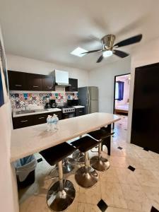 a kitchen with a table and a ceiling fan at Amplio loft 6 pax cerca de Paseo de Montejo in Mérida