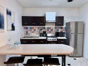 a kitchen with a stainless steel refrigerator and a table at Amplio loft 6 pax cerca de Paseo de Montejo in Mérida