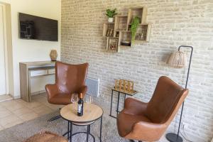 a waiting room with two chairs and a table at La Grange aux Cyprès, maison d'hôtes de charme in Monsempron-Libos