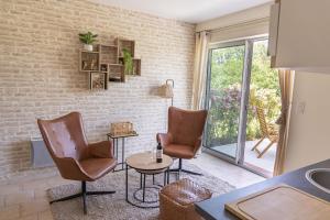 a living room with two chairs and a table at La Grange aux Cyprès, maison d'hôtes de charme in Monsempron-Libos