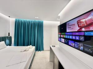 a bedroom with a bed and a flat screen tv at Hotel AURA in Sarandë