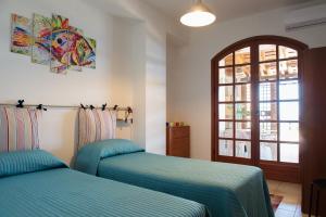 ein Schlafzimmer mit zwei Betten und einem Fenster in der Unterkunft Casa di Mare Barabba in Santa Teresa di Riva
