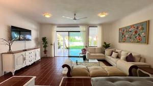 Una sala de estar con un sofá y un televisor en The Villa of Dreams, en Cancún